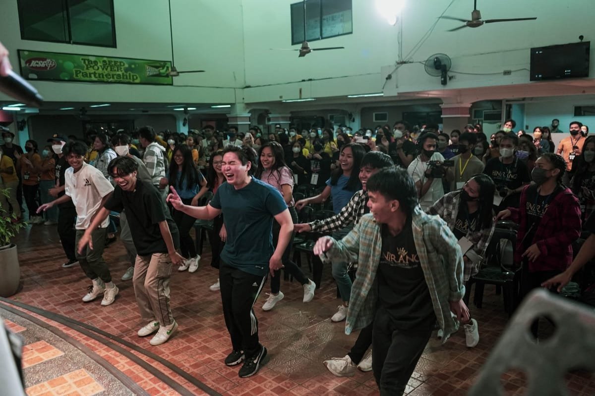 Young people laughing and dancing together at a JCSGO youth gathering